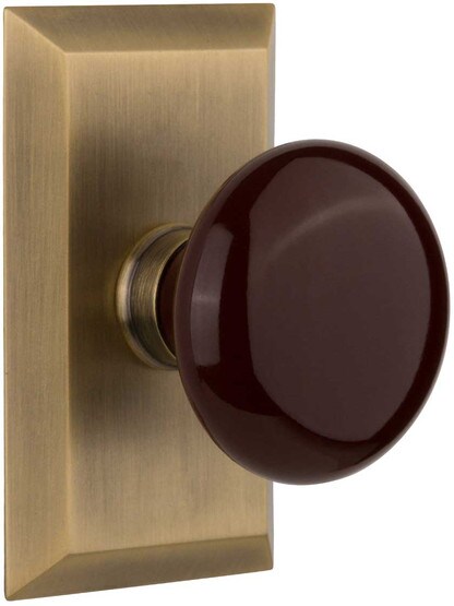 New York Rosette Door Set with Brown Porcelain Knobs in Antique Brass.